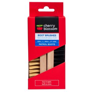 This image shows the packaging of the Cherry Blossom Leather Boot Care Brush Set. The set is packaged in a vibrant red box with a clear window displaying two brushes: one with stiff black bristles for tough dirt removal, and another with softer natural br